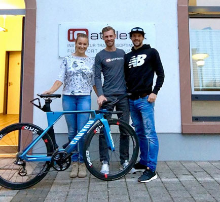 Der Triathlonprofi Patrick Lange (rechts) mit den iQ athletik Mitarbeitern Laura-Sophie Usinger und Sebastian Mühlenhoff