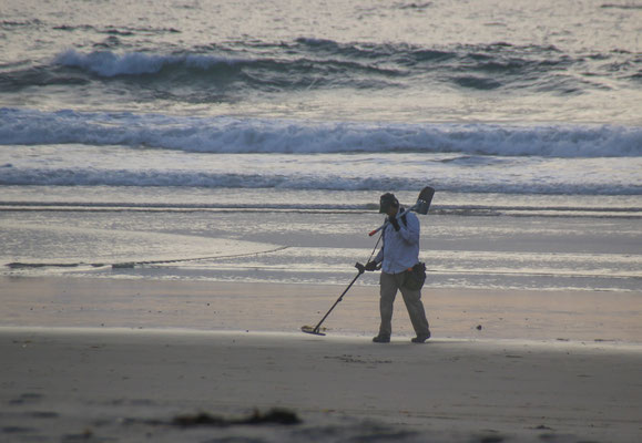 Schmuckjäger mit Metalldetektor am Strand