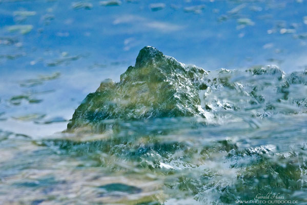 Bergspiegelung in einer am Morgen gefronenen Wasserpfütze.