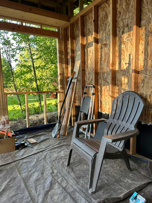 May 12, 2025. Interior view of OSB-sheathed wall and rain-tarp ceiling.
