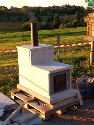 Poêle d'expo en pierre volcanique avec une deuxième peau en pierre calcaire du Jura