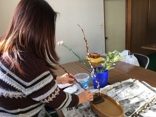 初めての盛花。小判型水盤に直立型のお稽古です。副枝の位置づけを考えるMichiyoさん。