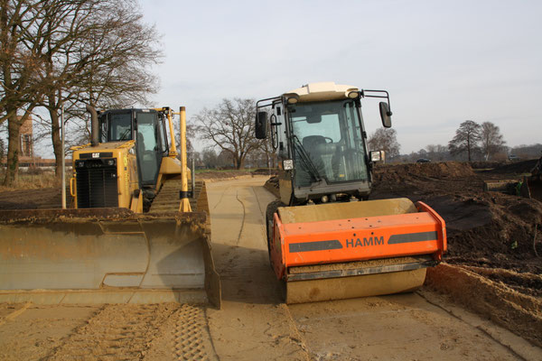 Bagger und Planierwalze auf einer Baustelle