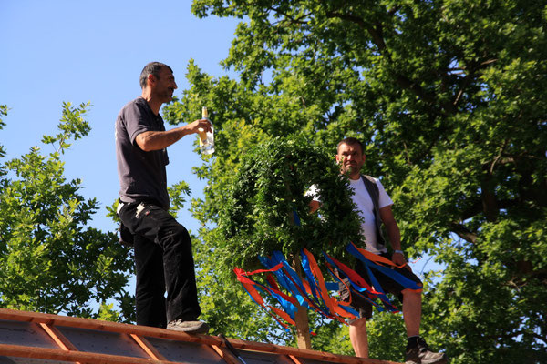 Zimmerleute auf dem Dach der Remise beim Richtfest 2017