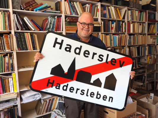 Die Diskussion um die Zweisprachigkeit hält bis heute an - René Rasmussen mit Entwurf für ein zweisprachiges Ortsschild. Foto: C. Schumann, 2020