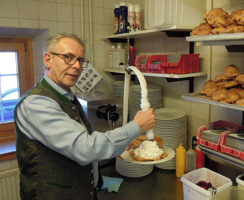 „Windbeutelgräfin“ Helmut Stemmler vollendet einen Windbeutel mit ungesüßter Sahne. Foto: Christoph Schumann, 2020