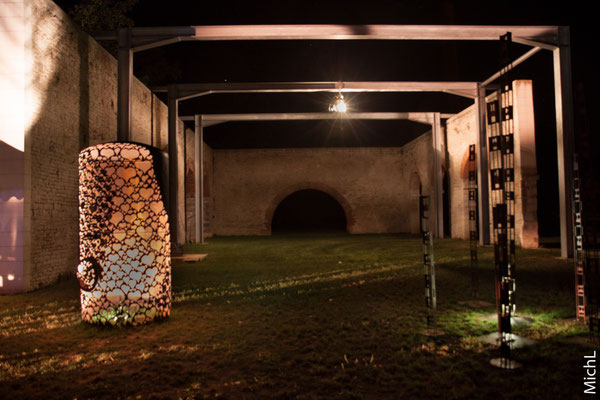 Sculpture monumentale en acier, éclairée de nuit
