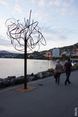 Sculpture monumentale en acier devant un lac