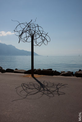 Sculpture monumentale en acier devant un lac