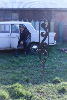 Sculpture en acier devant une voiture