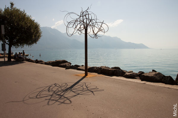 Sculpture monumentale en acier devant un lac