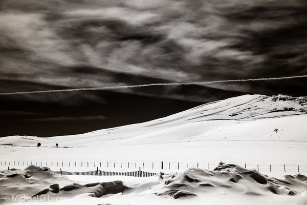 Winter snowfield cut with contrail in the sky. Photographed with infrared converted camera. Central Utah