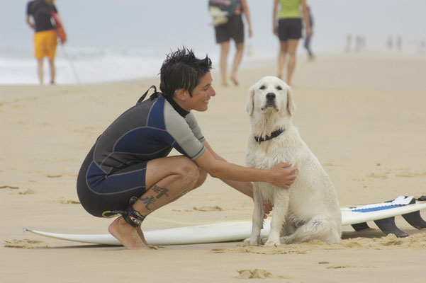 Frau mit Hund am Strand, Surferin mit Surfbrett