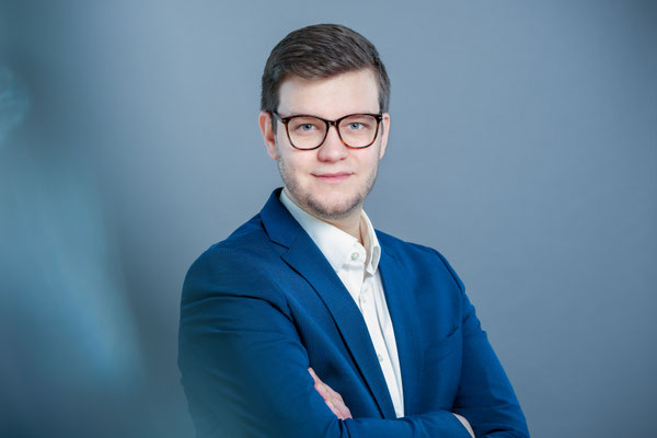 Businessportrait von einem Mann. Blauer Anzug und blauer Hintergrund