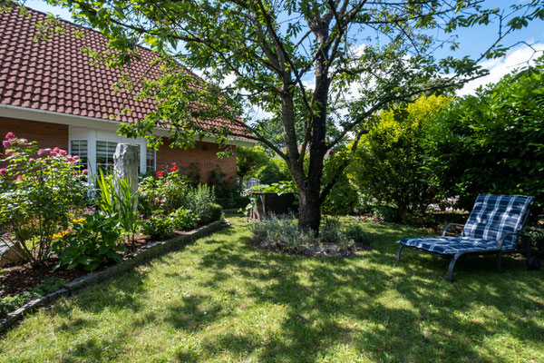eine Liege im grünen Garten vom Einfamilienhaus