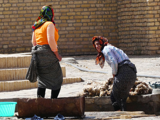 Women cleaning the sheep fur at the well.