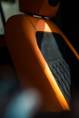 Die Seitenansicht des Fahrersitzes - Die erhabene Ziersteppung mit Kontrastfarbe in Orange ist gut zu erkennen