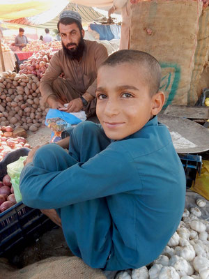 子供もお父さんの手伝いで野菜を売る。