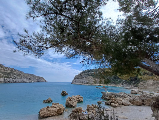 Auf dem Foto sind die bizarren Felsformationen im Meerwasser der Anthony Quin Bay zu sehen. Am oberen Rand des Fotos sind Äste eines Pinienbaumes zu sehen.