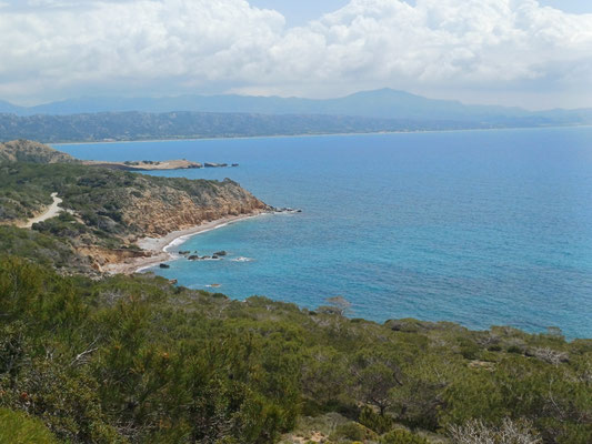 Auf dem Foto ist ein türkisgesprenkeltes Meer zu sehen und eine Küstenlandschaft.