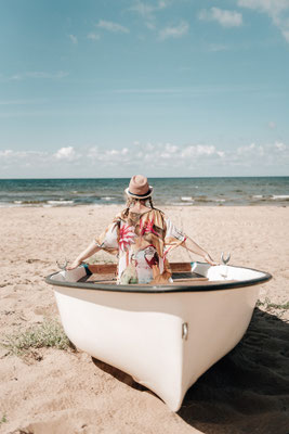 Fotografin [Ihr Vor- und Nachname] sitzt entspannt in einem Boot und blickt ruhig auf das Wasser.