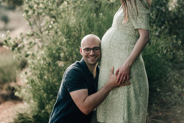 Schwangerschaftsshooting in der Wetterau: Vater schmiegt sich an den Babybauch, fotografiert von Szilvia Rölke.