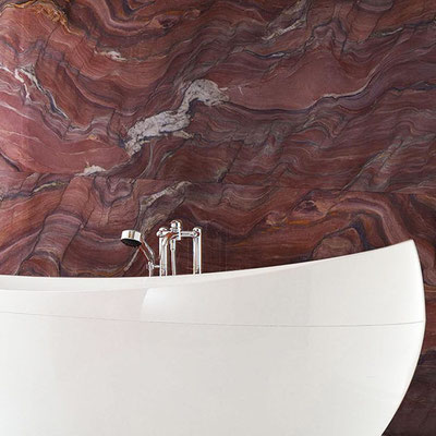 White self standing solid surface bathtub looks stunning when placed against red marble wall