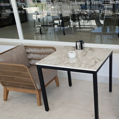 Square table topped with Sensa granite manufactured by Cosentino