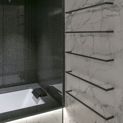 Porcelain bathtub fitted in black Corian surrounded with black solid surface walls