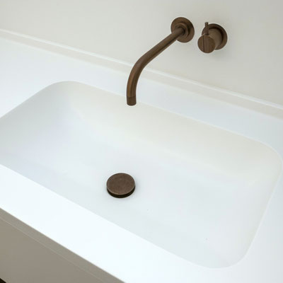 White solid surface washbasin integrated into the vanity 