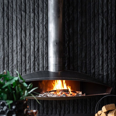 Natural stone wall behind the fireplace fabricated from Absolute Premium Black granite 