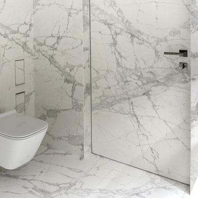 Bathroom walls and door clad in thin white and grey porcelain 