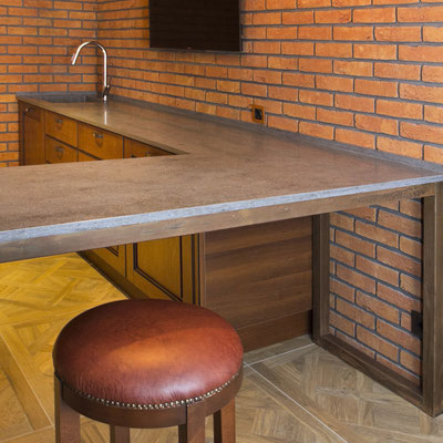 Kitchen table continuing into countertop fabricated from grey acrylic stone 