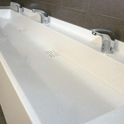 Triple acrylic stone washbasin at a business centre wc with moulded water outlet grille 