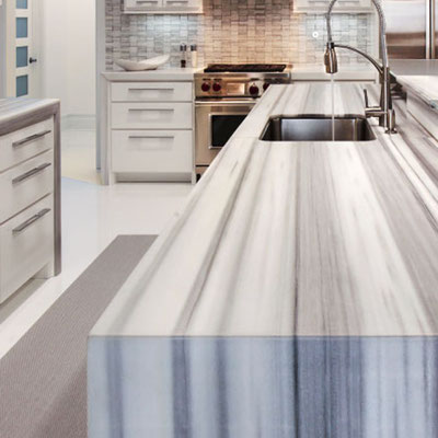 Kitchen island clad in grey and white striped marble