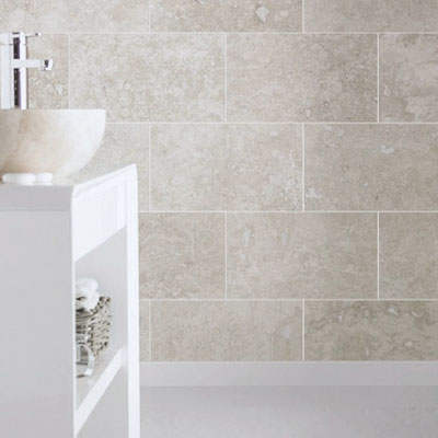 Bathroom wall clad in travertine tiles