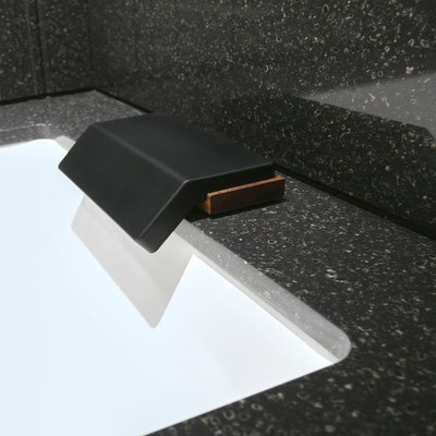 White porcelain bathtub clad in black Corian joint seamlessly with splashwalls from the same solid surface / fabricator - Gforma
