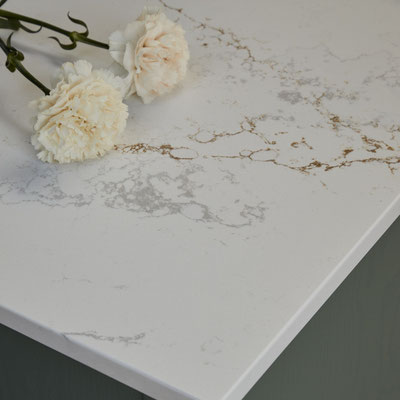 Table covered in white Silestone panel with golden and silver veins