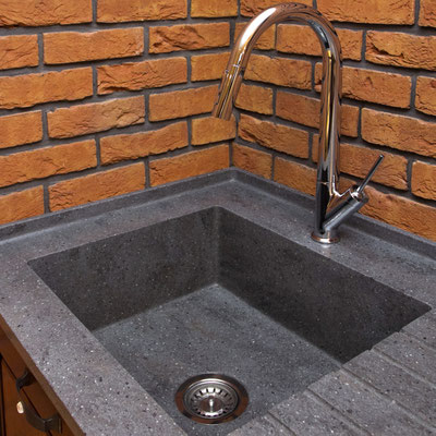 Dark grey acrylic solid surface washbasin with water drain integrated into kitchen worktop
