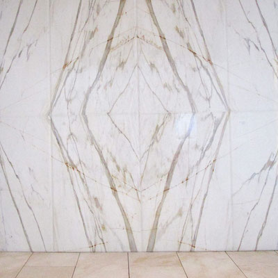 White marble wall with mirrored veiny pattern - two slabs of marble mirroring each other placed side by side