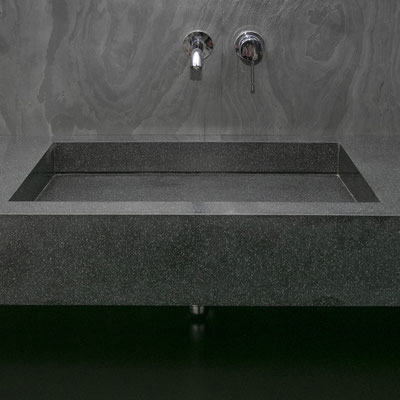 Black solid surface vanity with a splashwall and integrated wide sink 