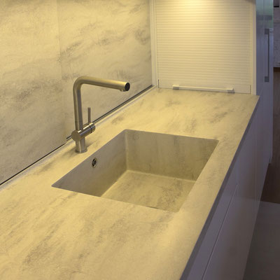 Solid surface worktop with integrated sink, and sliding splashwall with hidden cupbords / fabricator: Gforma