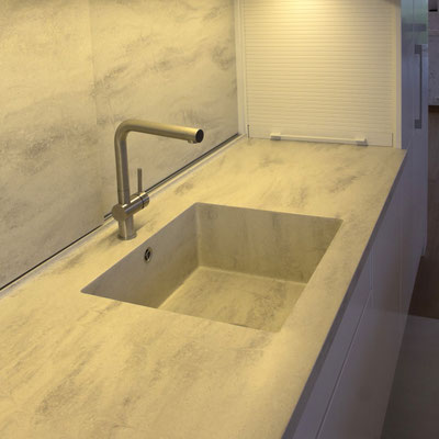 Solid surface worktop with integrated sink, and sliding splashwall with hidden cupbords 