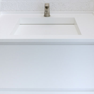 White bathroom vanity with edge drain at the back fabricated from acrylic stone / fabricator: Gforma