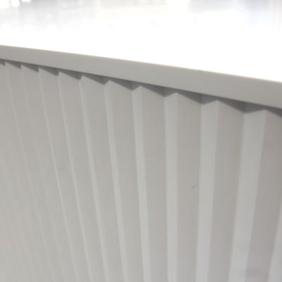 Reception desk from white solid surface, decorated with vertical moulds / fabricator: Gforma