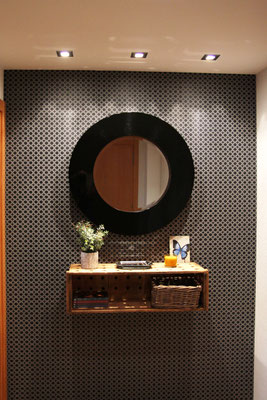 Hall de una clienta decorado con espejo y caja de madera de la tienda