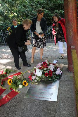 Gedenken an der Weltfriedensglocke Berlin - Menschen legen Blumen nieder. Foto: Helga Karl