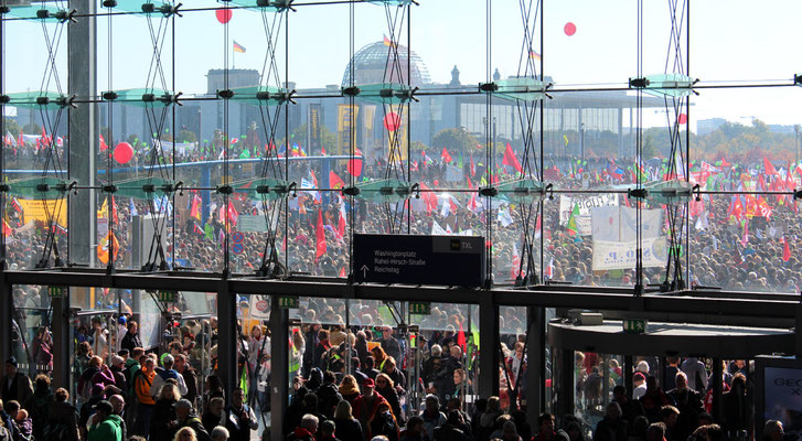 Zehntausende mit Fahnen vor dem Hauptbahnhof, Blick auf Reichstag. Großdemo Stop TTIP Berlin.  Foto: Helga Karl 10.10.2015