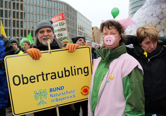 Mann und Frau mit Schild "Obertraubling" vom Bund Naturschutz in Bayern bei der Demo 2017 in Berlin "Wir haben es satt". Foto: Helga Karl