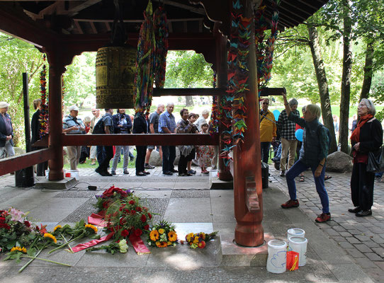 Besucher der Gedenkfeier 6.August stellen sich an, um nacheinander die Weltfriedensglocke zu läuten. Foto: Helga Karl